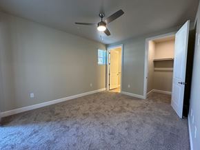 Visalia apartment for rent - A room with a ceiling fan and carpeted floor.