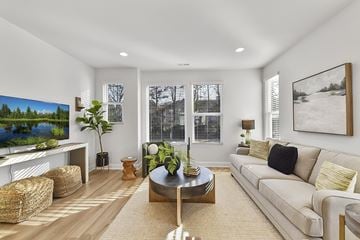 Charlotte townhouse for rent - A living room with a large couch, a coffee table, and a painting on the wall.