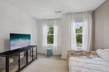 Gallatin townhouse for rent - A modern bedroom with a large bed and a television.