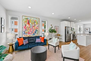 Charlotte townhouse for rent - A living room with a blue couch and a large painting on the wall.