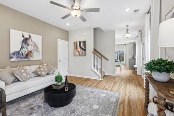 Smyrna townhouse for rent - A living room with a white couch and a painting of a horse on the wall.