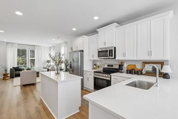 Charlotte townhouse for rent - A modern kitchen with white cabinets and appliances.