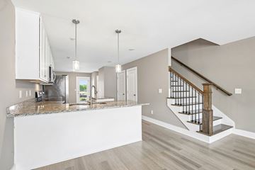 Lebanon townhouse for rent - A modern kitchen with a marble countertop and a staircase with a wooden handrail.