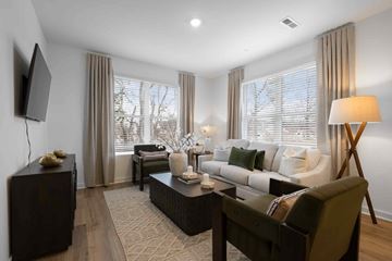 Gallatin townhouse for rent - A living room with a dark brown sofa, a wooden coffee table, and a television on the wall.
