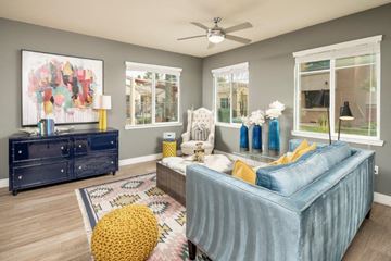 Tempe apartment for rent - a living room with a blue couch and a ceiling fan