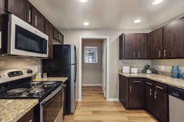 Chandler apartment for rent - A kitchen with dark wood cabinets and granite countertops.