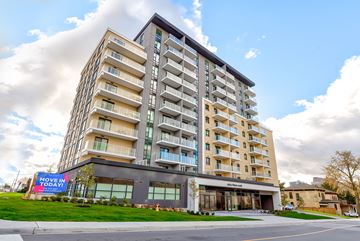 Kitchener apartment for rent - A large apartment building with a sign that says "Move in Today!" in front of it.