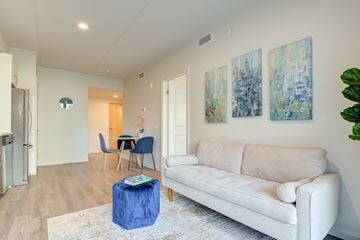 Kitchener apartment for rent - A living room with a white couch and a blue ottoman.