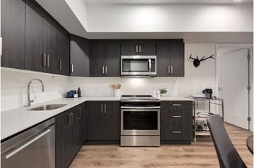 Calgary apartment for rent - A modern kitchen with dark wood cabinets and stainless steel appliances.