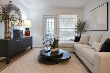 Austin apartment for rent - A living room with a white couch, a coffee table, and a side table with a lamp and a vase.