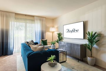 Laurel apartment for rent - A living room with a blue couch and a television displaying the word "Foxfire".