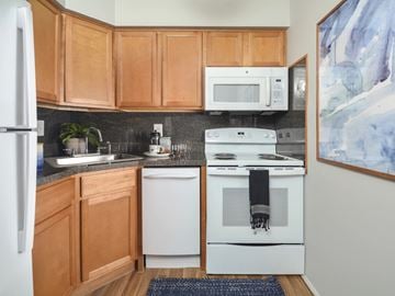 Mantua apartment for rent - A kitchen with wooden cabinets and white appliances.