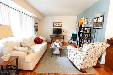 Spring Lake Heights apartment for rent - A living room with a white couch and a white chair with a pattern on it.