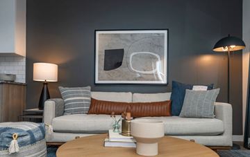 Kingston apartment for rent - A modern living room with a grey couch, a coffee table, and a large abstract painting on the wall.