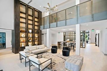 North Palm Beach apartment for rent - A modern living room with a white sofa and a glass display cabinet.