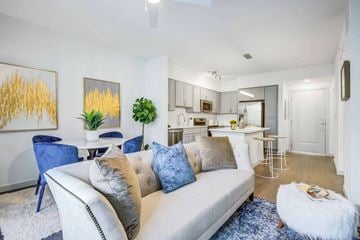 Palm Beach Gardens apartment for rent - A living room with a white couch and blue chairs.