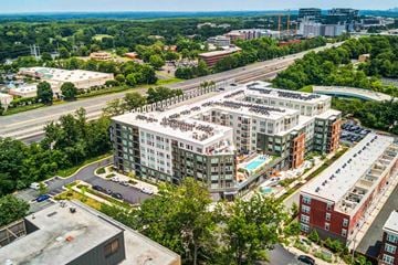 Reston apartment for rent - A large apartment complex is surrounded by trees and a highway.