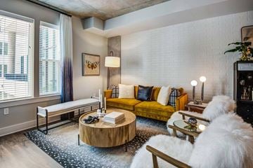 Reston apartment for rent - A living room with a yellow couch and a wooden coffee table.