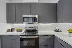 Mesa apartment for rent - A modern kitchen with a stove top oven and microwave above it.