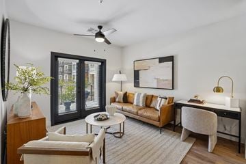 Mesa apartment for rent - A living room with a brown couch, a white coffee table, and a painting on the wall.