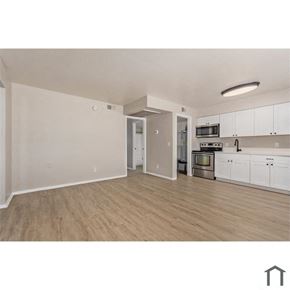 Phoenix apartment for rent - an open living room and kitchen with wood flooring and white cabinets