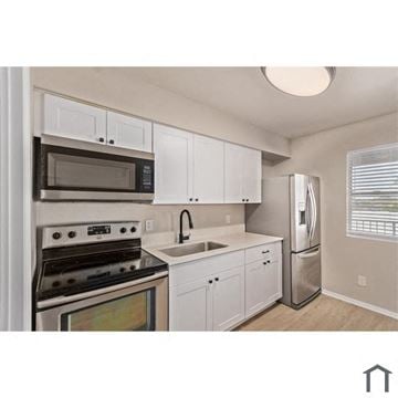 Phoenix apartment for rent - A kitchen with white cabinets and stainless steel appliances.