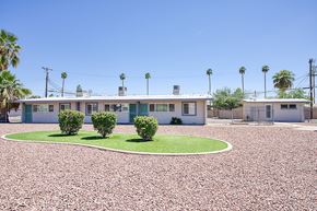 Phoenix apartment for rent - A building with a white roof and a green lawn in front.
