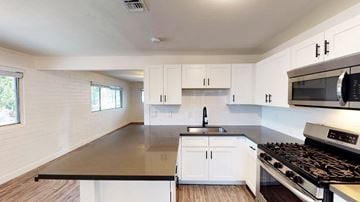 Scottsdale apartment for rent - A modern kitchen with white cabinets and a black countertop.