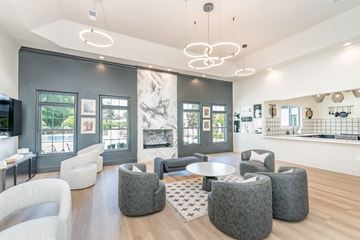 Augusta apartment for rent - A modern living room with a large grey sofa and a round grey ottoman.