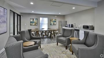 Concord apartment for rent - A living room with grey couches and a dining table.