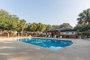 Moultrie apartment for rent - A swimming pool surrounded by a concrete patio and a small building.