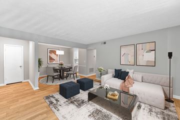 Smyrna apartment for rent - A living room with a white couch, a coffee table, and a dining table with chairs.