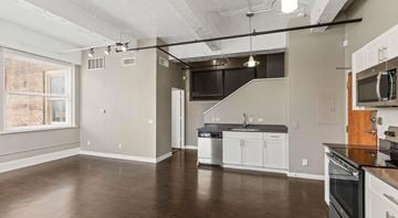 Fort Worth apartment for rent - A spacious kitchen with white cabinets and a wooden island.