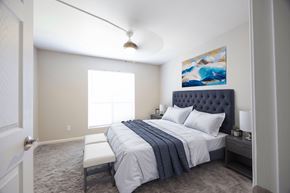 Huntsville apartment for rent - a bedroom with a white bed and a blue and white comforter
