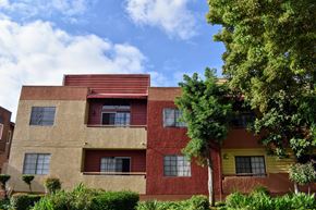 Glendale apartment for rent - A red and yellow building with a tree in front.