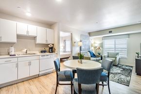 Centennial apartment for rent - a kitchen with white cabinets and a table and chairs at Parks Residential - Denver, Centennial, CO 80111