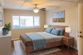 Sacramento apartment for rent - A bedroom with a bed, nightstand, and a painting on the wall.