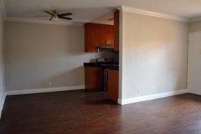 Los Angeles apartment for rent - an empty living room with a kitchen and a ceiling fan