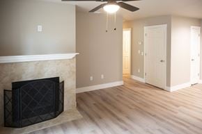 Cameron Park apartment for rent - A living room with a fireplace and a ceiling fan.