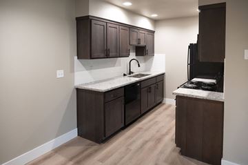 Cameron Park apartment for rent - A kitchen with dark brown cabinets and a white countertop.
