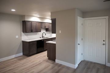 Cameron Park apartment for rent - A kitchen with brown cabinets and a white door.