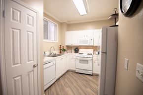 Temecula apartment for rent - A white kitchen with a refrigerator on the right.
