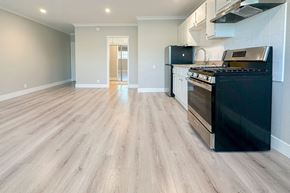 Hollywood apartment for rent - A kitchen with a black oven and wooden flooring.