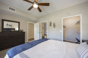 Pearland apartment for rent - A bedroom with a large bed and a ceiling fan.