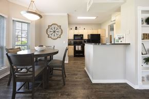 Pearland apartment for rent - A kitchen with a table and chairs in front of a window.