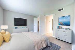 Stafford apartment for rent - A bedroom with a large bed and a television on the wall.