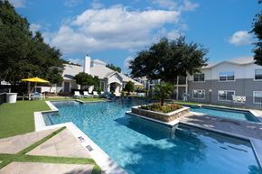 Frisco apartment for rent - A large swimming pool with a small waterfall and a hot tub.