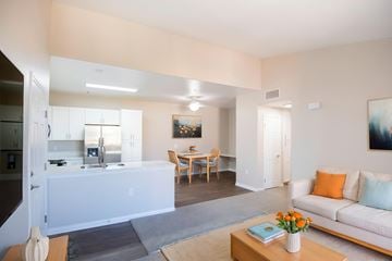 Murrieta apartment for rent - A living room with a white couch and a coffee table with a vase of flowers on it.