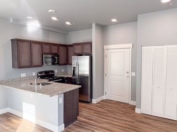 Reno apartment for rent - A kitchen with brown cabinets and a granite countertop.