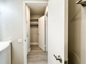 West Hollywood apartment for rent - A white door with a silver handle is open to a hallway.